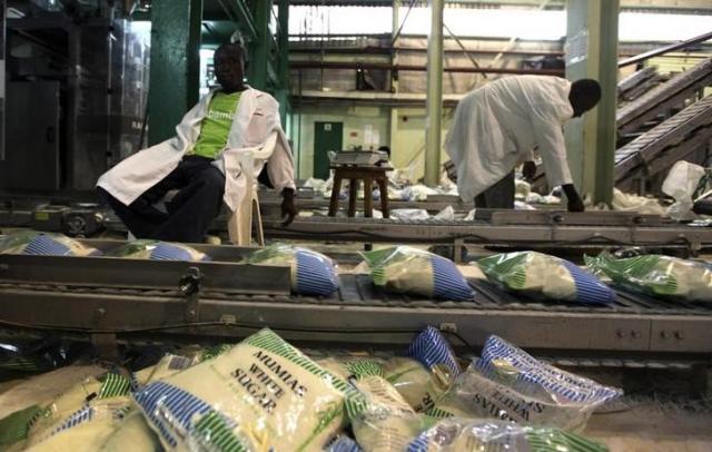 Workers arrange packets of sugar on a conveyor belt at the Mumias sugar factory in western Kenya April 29 2010. REUTERSNOOR KHAMIS