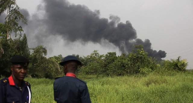 Nigerian civil defense corps officials secure the area following an explosion at a gasoline pipeline at Arepo, in Ogun, Nigeria, Wednesday, Jan. 23, 2013.  The gasoline pipeline runs through southwest Nigeria and this attack is being seen as a worrying expansion to the unchecked thefts which have become an incredibly lucrative business for criminal gangs hitting the country's petroleum-based economy.  Officials with Nigerias Security and Civil Defense Corps told The Associated Press that they blamed the attack on a group of thieves who have been increasingly targeting pipelines in the region. (AP Photo/Sunday Alamba)/NIN104/969994015390/1301232017