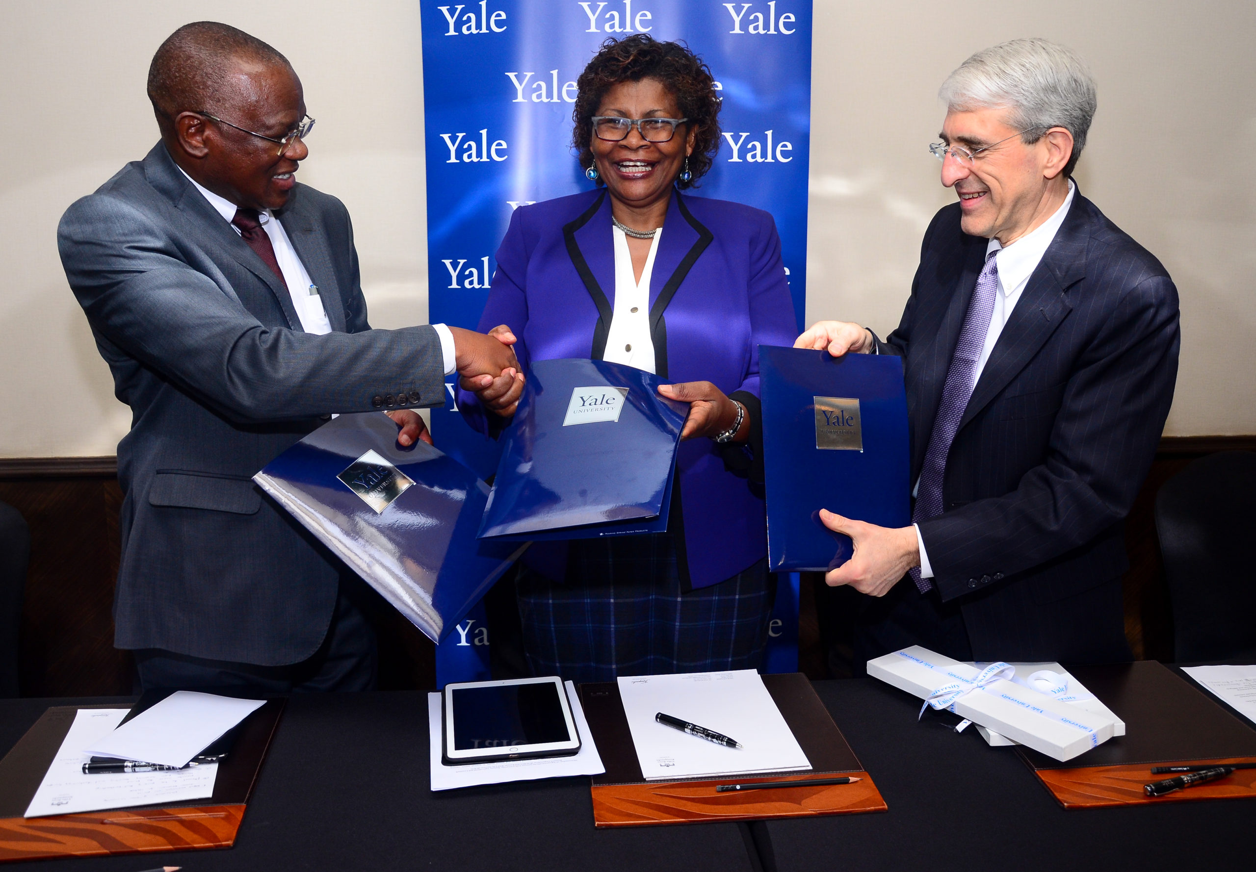 Yale University President Peter Salovey (right), Kenya Agricultural & Livestock Research Organisation (KALRO) Deputy Director Dr. Felister Makini and Kenya Wildlife Service (KWS) Deputy Director Dr. Samuel Kasiki exchange copies of the agreement after signing the Memorandum of Understanding on Friday.