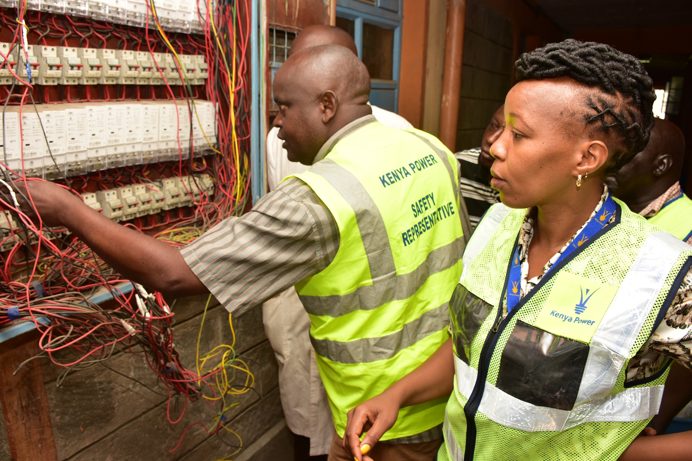 Kenya Power Revenue Protection Unit officer Jervase Ndaru and Security Officer Stella Mutuku disconnecting illegal power connections at Tassia in Nairobi 1