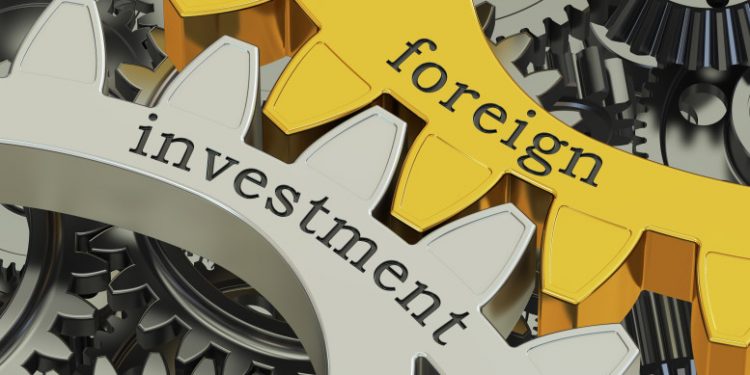 foreign investment concept on the gearwheels, 3D rendering