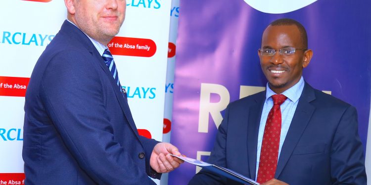 Barclays Director of Retail and Business Banking David Hardisty and Centum Real Estate Managing Director Samuel Kariuki exchange documents during the sign...