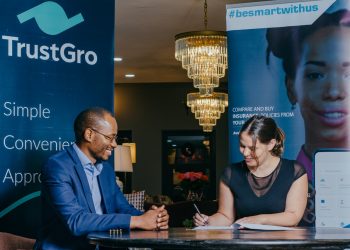 TrustGro  CEO,Tonderai  Mutesva looks on as  mTek CEO Bente  Krogmann signs the partnership deed that will see the two organisations collaborate to provide  Kenyans  with  affordable insurance  premium financing