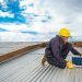 A Sun King Energy Officer installs a solar panel on a customer’s roof in Kenya.jpg