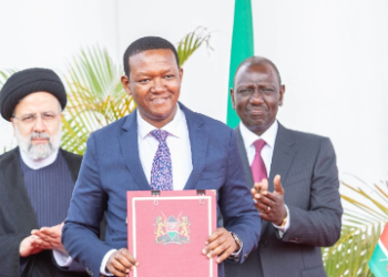 Foreign Affairs CS Alfred Mutua holding pact signed between Kenya and Iran. Looking on is President William Ruto(R) and President Ebrahim Raisi of Iran