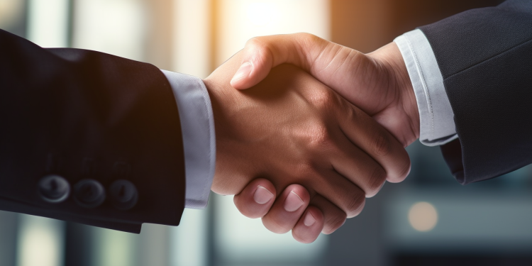 Alt text: A close-up view of two account managers shaking hands after implementing an account planning strategy.