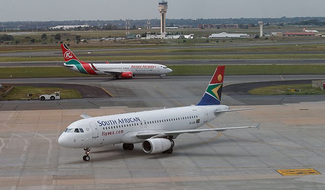 FILE PHOTO: A South African Airways Airbus A320-200 aircraft (bottom) arrives as a Kenya Airways Boeing 737-800 aircraft prepares to take off at the OR Tambo International Airport in Johannesburg, South Africa, March 8, 2017. REUTERS/Siphiwe Sibeko/File Photo